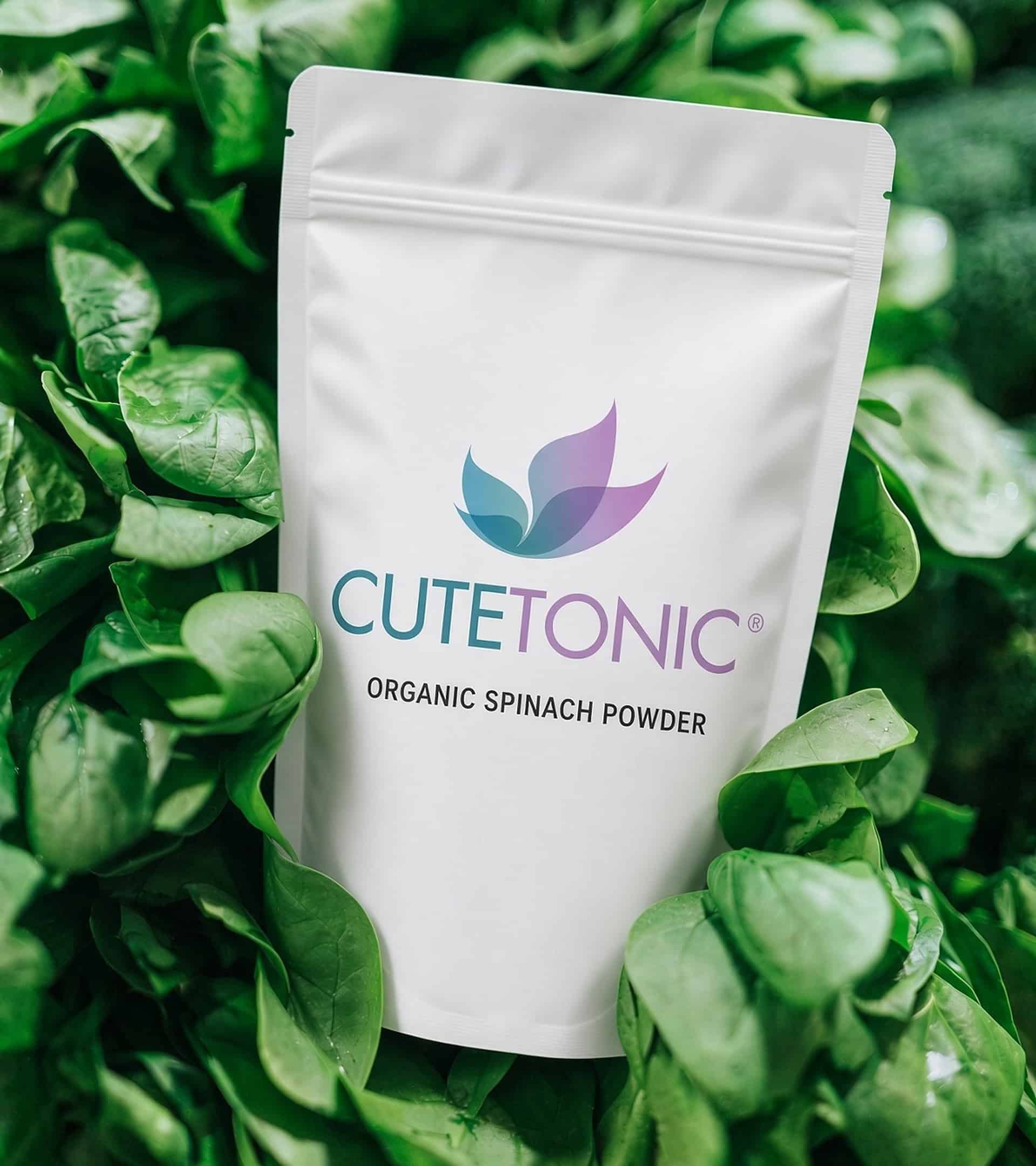 Cutetonic organic spinach powder pouch among fresh spinach leaves
